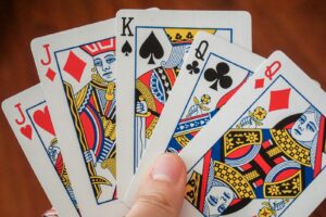 Winning poker mindset – a hand holding a poker card.