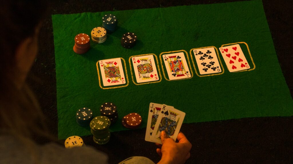 A poker player calculating live poker bankroll on a notepad beside chips