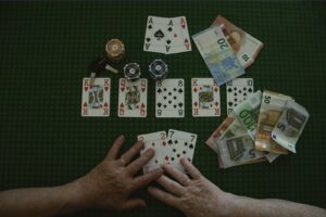 A man is using advanced bluffing techniques while playing a game of poker cards on a table.